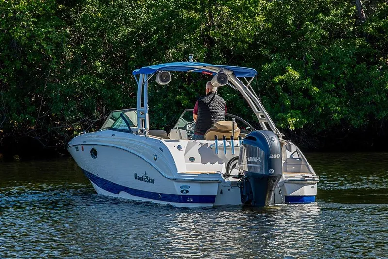 Slide: The Image of 2019 NauticStar 243DC Sport Deck boat cruising on a calm lake. - 34