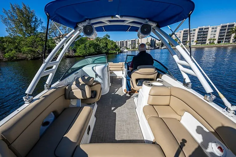 Slide: The Image of 2019 NauticStar 243DC Sport Deck boat cruising on a sunny day, featuring spacious seating. - 8