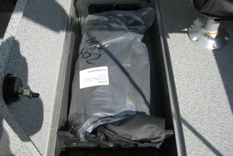 Slide: The Image of 2026 Lund 2075 Fisherman boat interior storage compartment with packaged equipment. - 13