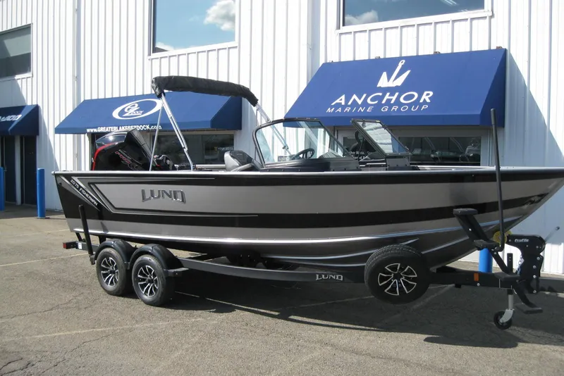 Slide: The Image of 2026 Lund 2075 Fisherman boat displayed at Anchor Marine Group dealership. - 2