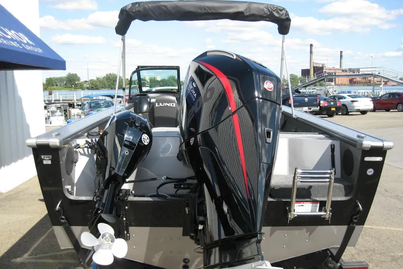 Slide: The Image of 2026 Lund 2075 Fisherman boat with dual outboard motors, docked outdoors. - 6