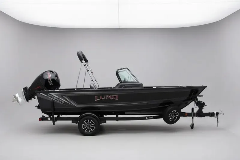 The Image of 2025 Lund 1875 Impact XS Sport boat on trailer in studio setting. - 0