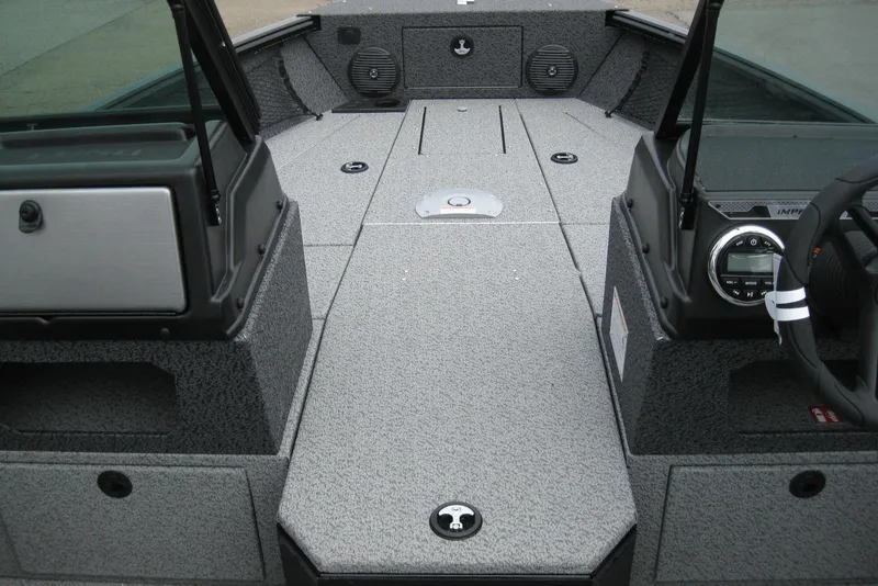 Slide: The Image of 2025 Lund 1875 Impact XS Sport boat interior with modern dashboard and spacious deck. - 13