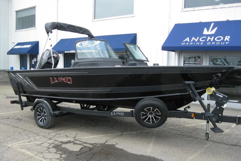 Slide: The Image of 2025 Lund 1875 Impact XS Sport boat on trailer outside Anchor Marine Group. - 2