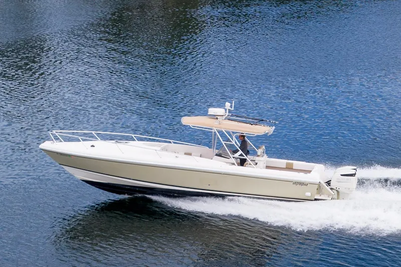 The Image of 1999 Intrepid 366 boat cruising on water, side view, with clear blue waves. - 0
