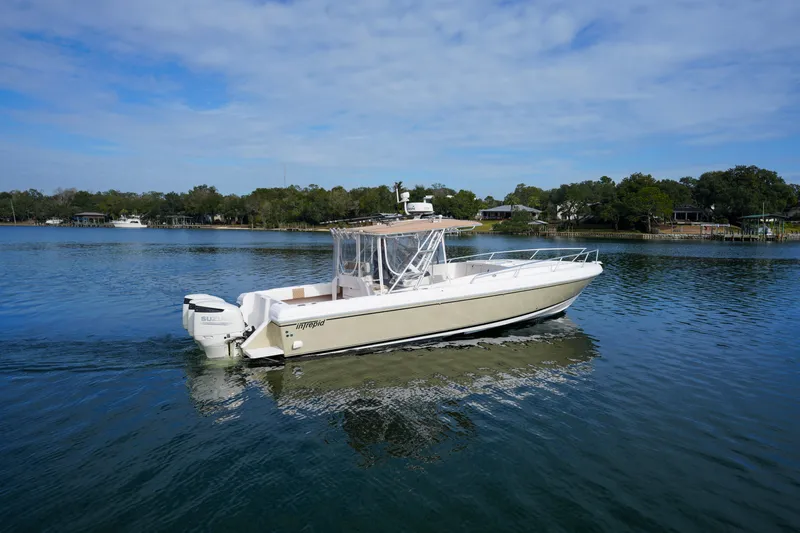 Slide: The Image of 1999 Intrepid 366 boat on calm water, clear sky, surrounded by trees. - 10