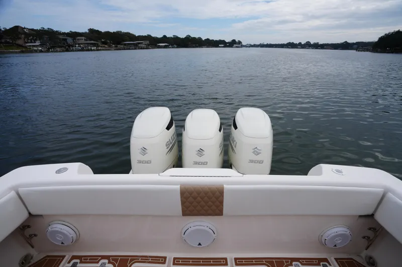 Slide: The Image of 1999 Intrepid 366 boat with triple Suzuki 300 engines on a calm lake. - 11