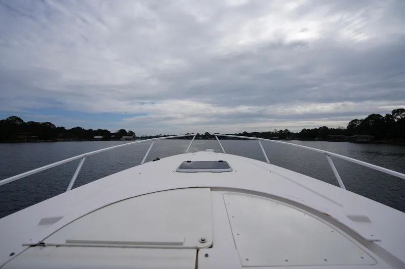 Slide: The Image of 1999 Intrepid 366 boat cruising on a calm lake under a cloudy sky. - 13