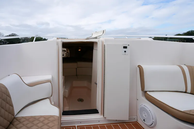 Slide: The Image of 1999 Intrepid 366 boat interior with cushioned seating and open cabin door. - 14
