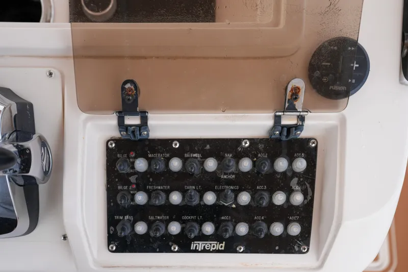 Slide: The Image of 1999 Intrepid 366 boat control panel with labeled switches and protective cover. - 20