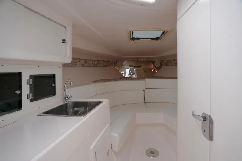 Slide: The Image of 1999 Intrepid 366 boat interior with sink, seating, and storage cabinets. - 22