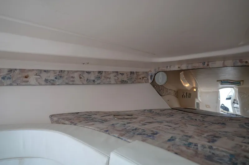 Slide: The Image of Interior cabin of a 1999 Intrepid 366 boat with patterned upholstery and white accents. - 24