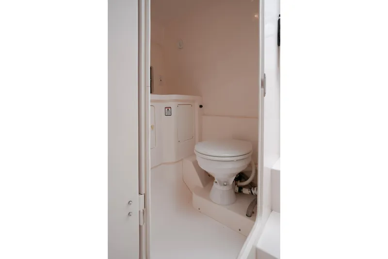 Slide: The Image of 1999 Intrepid 366 boat interior bathroom with white marine toilet. - 25