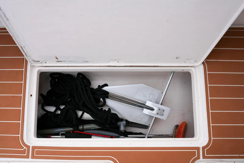 Slide: The Image of Storage compartment on 1999 Intrepid 366 boat with anchor, rope, and cleaning tools. - 30