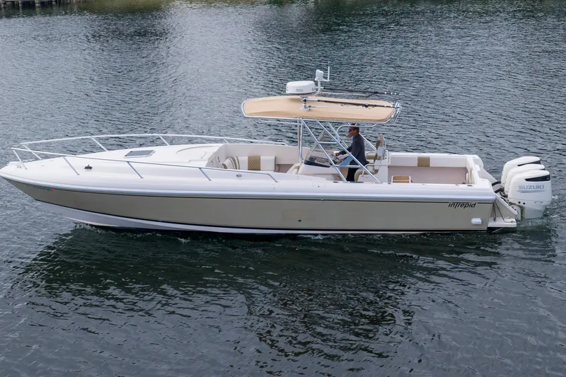 Slide: The Image of 1999 Intrepid 366 boat cruising on water with Suzuki outboard engines. - 33