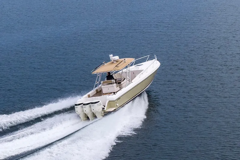 Slide: The Image of 1999 Intrepid 366 boat cruising on open water with triple outboard engines. - 41