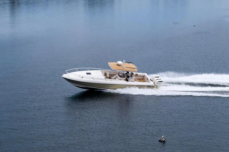 Slide: The Image of 1999 Intrepid 366 boat cruising on calm water with a pelican nearby. - 43