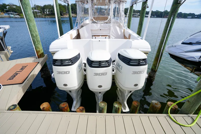 Slide: The Image of 1999 Intrepid 366 boat with triple Suzuki 300 outboard engines docked by the water. - 5