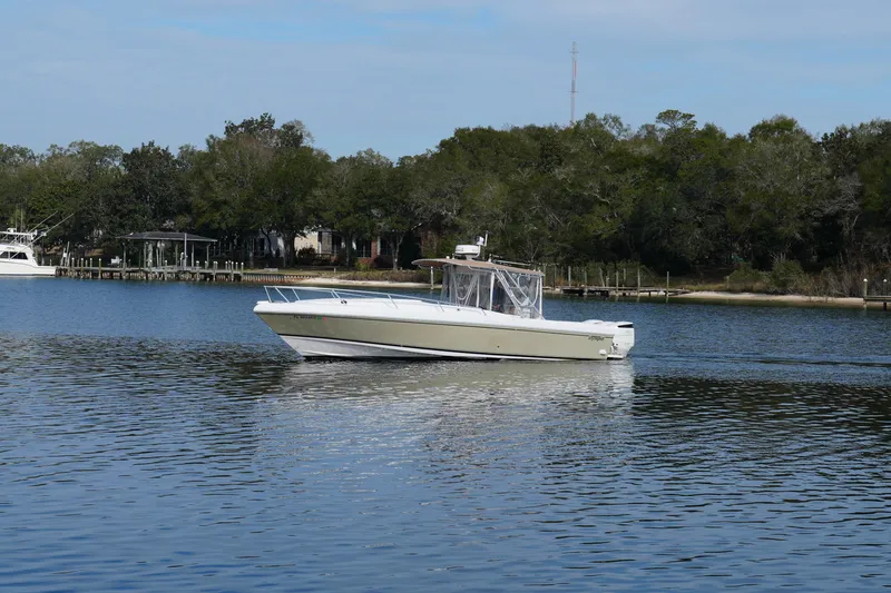 Slide: The Image of 1999 Intrepid 366 boat cruising on a calm lake with a forested shoreline. - 7