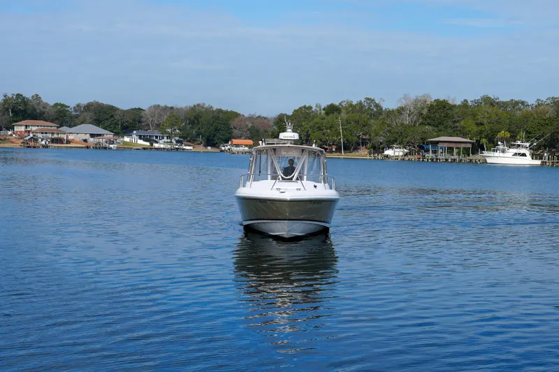 Slide: The Image of 1999 Intrepid 366 boat cruising on a calm lake with houses in the background. - 8