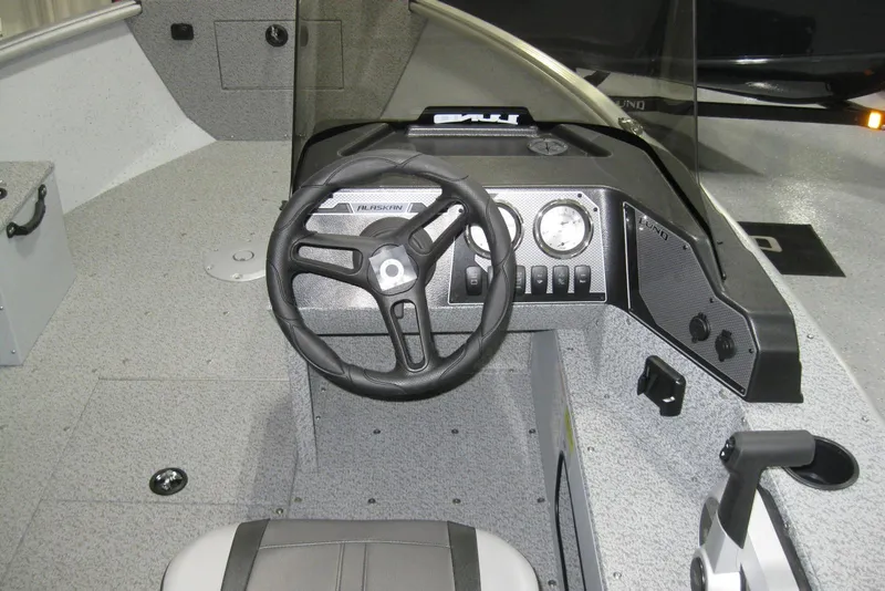 Slide: The Image of 2025 Lund 1800 Alaskan SS boat interior with steering wheel and dashboard controls. - 9