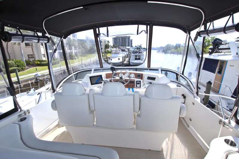 Slide: The Image of 2006 Silverton 39 Motor Yacht helm with white seating and modern controls. - 18