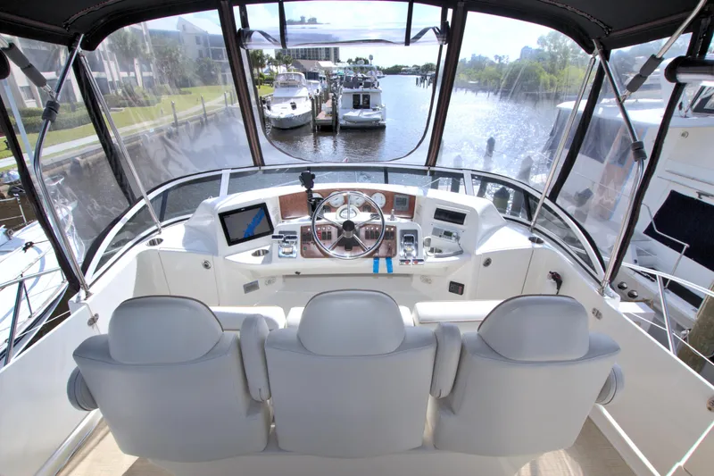 Slide: The Image of 2006 Silverton 39 Motor Yacht helm with three seats, overlooking marina. - 19
