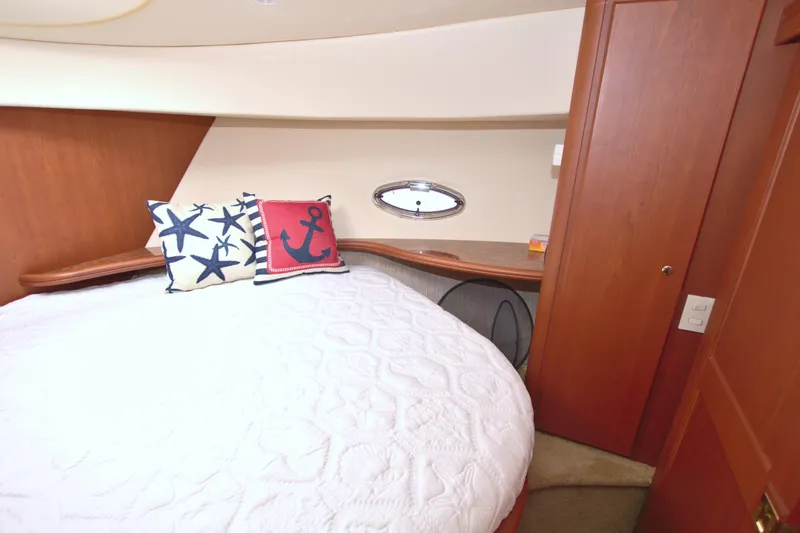 Slide: The Image of 2006 Silverton 39 Motor Yacht bedroom with nautical-themed pillows and cozy bedding. - 48
