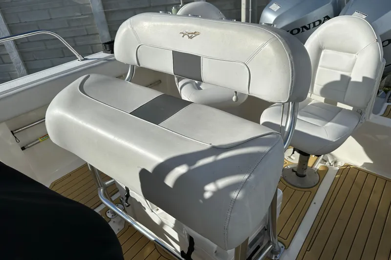 Slide: The Image of 2014 Tidewater 250 CC Adventure boat interior with white seating and Honda engines. - 13