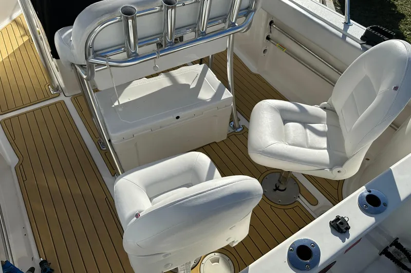 Slide: The Image of 2014 Tidewater 250 CC Adventure boat interior with white seating and teak-style flooring. - 14