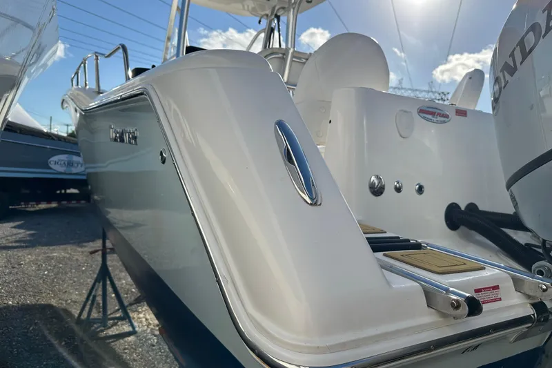 Slide: The Image of 2014 Tidewater 250 CC Adventure boat with Honda engine, parked outdoors under clear sky. - 28