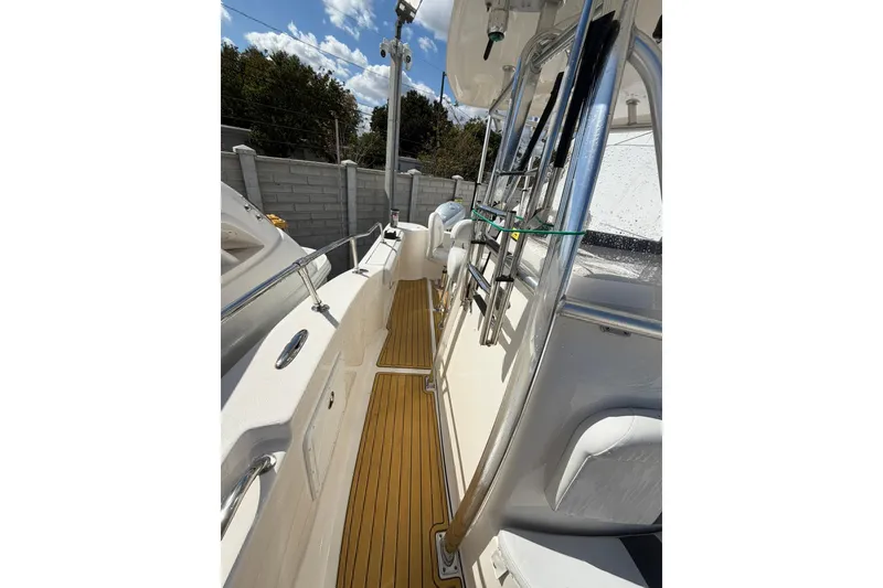 Slide: The Image of 2014 Tidewater 250 CC Adventure boat deck with stainless steel railings and wooden flooring. - 34