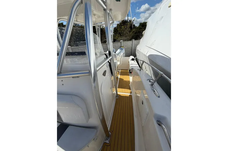 Slide: The Image of 2014 Tidewater 250 CC Adventure boat deck with stainless steel railings and wooden flooring. - 35
