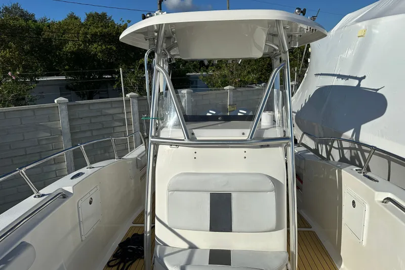 Slide: The Image of 2014 Tidewater 250 CC Adventure boat with T-top and seating, docked outdoors. - 9