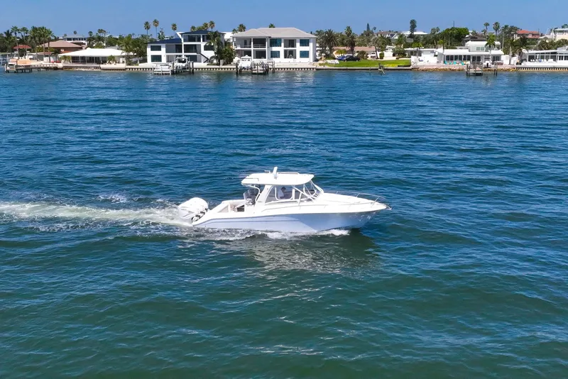 Slide: The Image of 2008 Hydra-Sports Vector 3500 VX cruising on a sunny waterfront with houses in the background. - 9