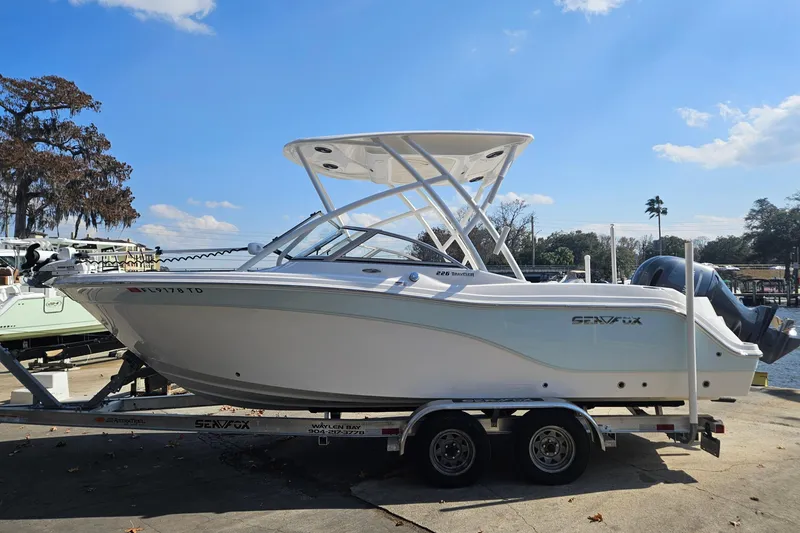 Slide: The Image of 2022 Sea Fox 226 Traveler boat with Yamaha outboard motor, docked near a bridge. - 4