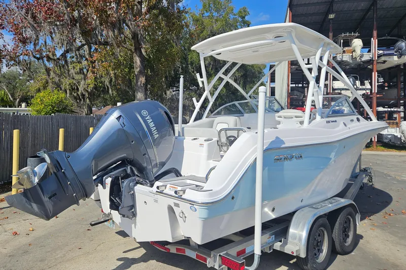 Slide: The Image of 2022 Sea Fox 226 Traveler boat on trailer, parked outdoors with trees in background. - 7