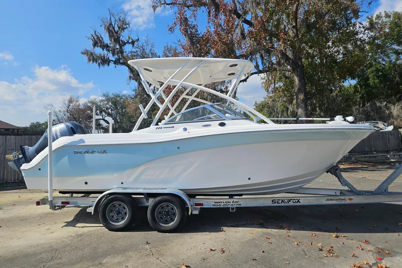 Slide: The Image of 2022 Sea Fox 226 Traveler boat on trailer, parked near a dock under a clear sky. - 8