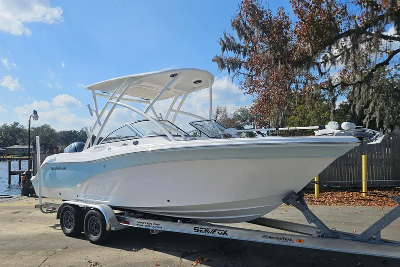 Slide: The Image of 2022 Sea Fox 226 Traveler boat interior with seating and steering wheel, docked by the water. - 9