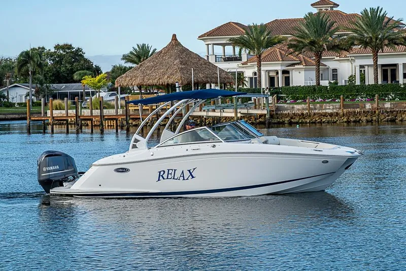 The Image of 2019 Cobalt 23SC boat cruising on water near luxury waterfront homes. - 0