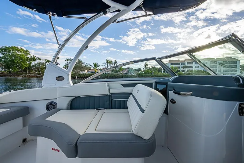Slide: The Image of 2019 Cobalt 23SC boat interior with seating, under a blue sky. - 13
