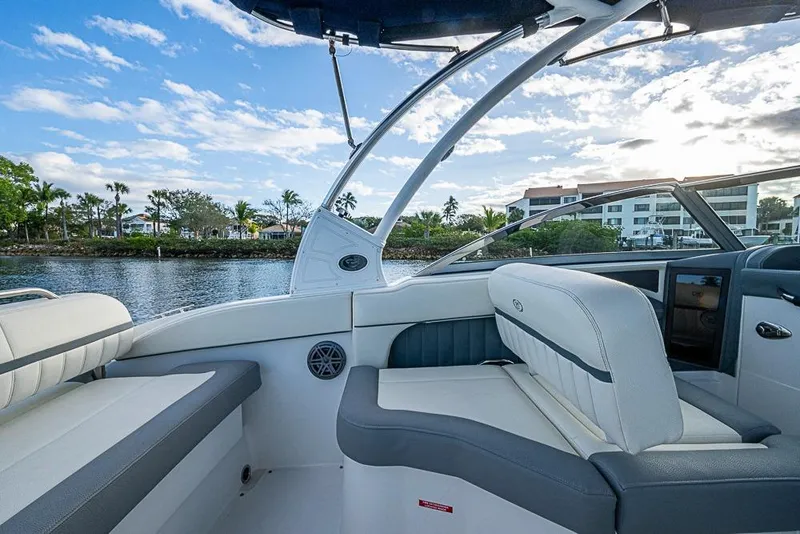 Slide: The Image of 2019 Cobalt 23SC boat interior with luxurious seating, scenic waterfront view. - 18