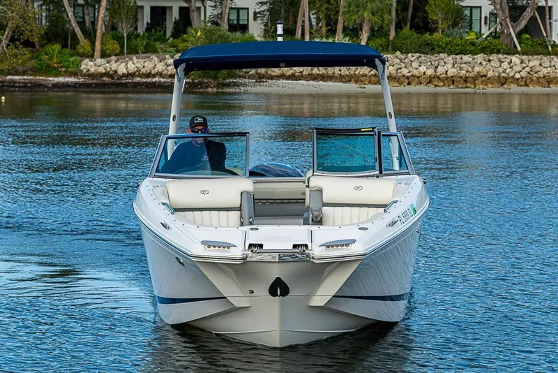 Slide: The Image of 2019 Cobalt 23SC boat cruising on a calm waterway with scenic background. - 2