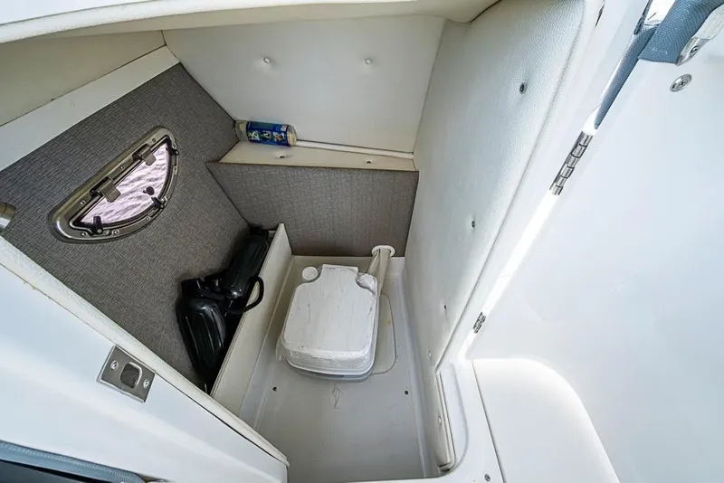 Slide: The Image of 2019 Cobalt 23SC boat interior with compact toilet and storage space. - 20