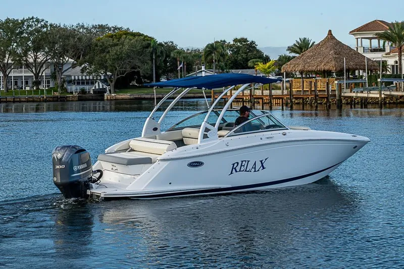 Slide: The Image of 2019 Cobalt 23SC boat cruising on a serene lake with scenic background. - 21