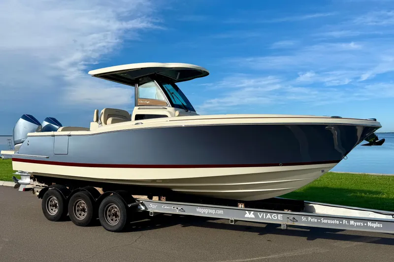 Slide: The Image of 2025 Chris-Craft Catalina 28 boat on trailer, parked near waterfront under blue sky. - 1