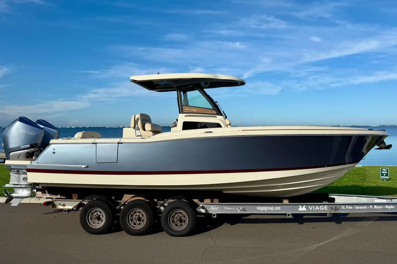 Slide: The Image of 2025 Chris-Craft Catalina 28 boat on trailer by the waterfront under a clear blue sky. - 4