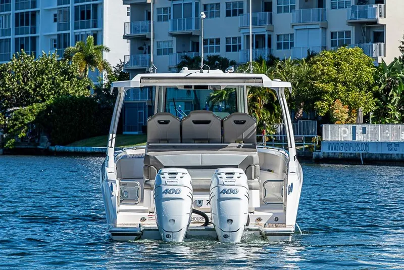 Slide: The Image of 2023 Tiara Yachts 34 LS with dual outboard engines on a sunny waterfront. - 12