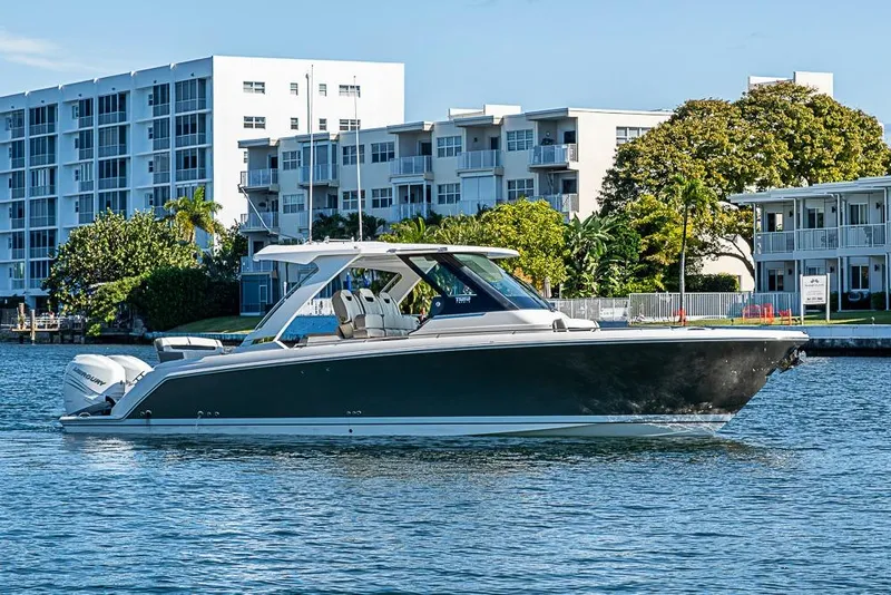 Slide: The Image of 2023 Tiara Yachts 34 LS boat on water near modern buildings. - 15