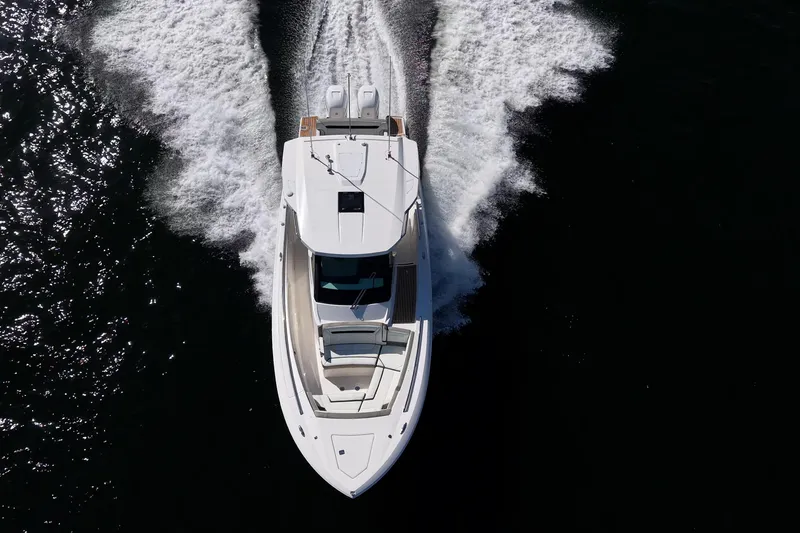 Slide: The Image of Aerial view of 2023 Tiara Yachts 34 LS cruising on water, creating a wake. - 2